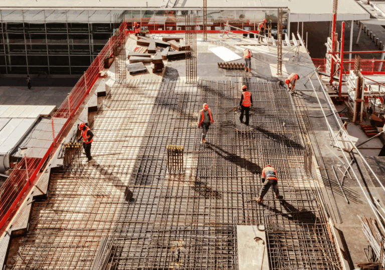 construction workers on a building rooftop laying concrete